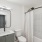 a bathroom with a shower and a single sink vanity